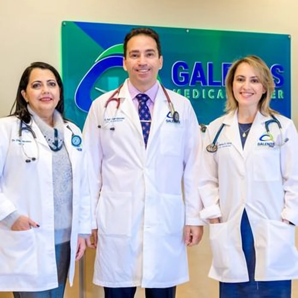 Doctors in white coats standing in front of the Galenos Medical Center sign